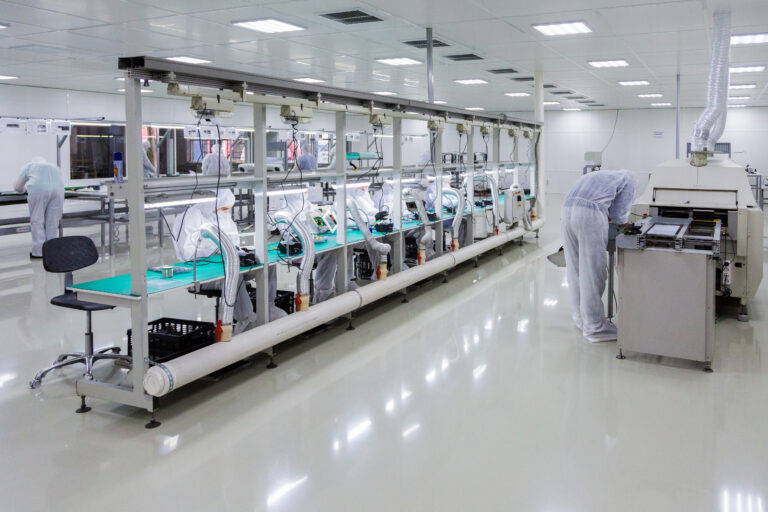 people in white isolating costumes working in laboratory